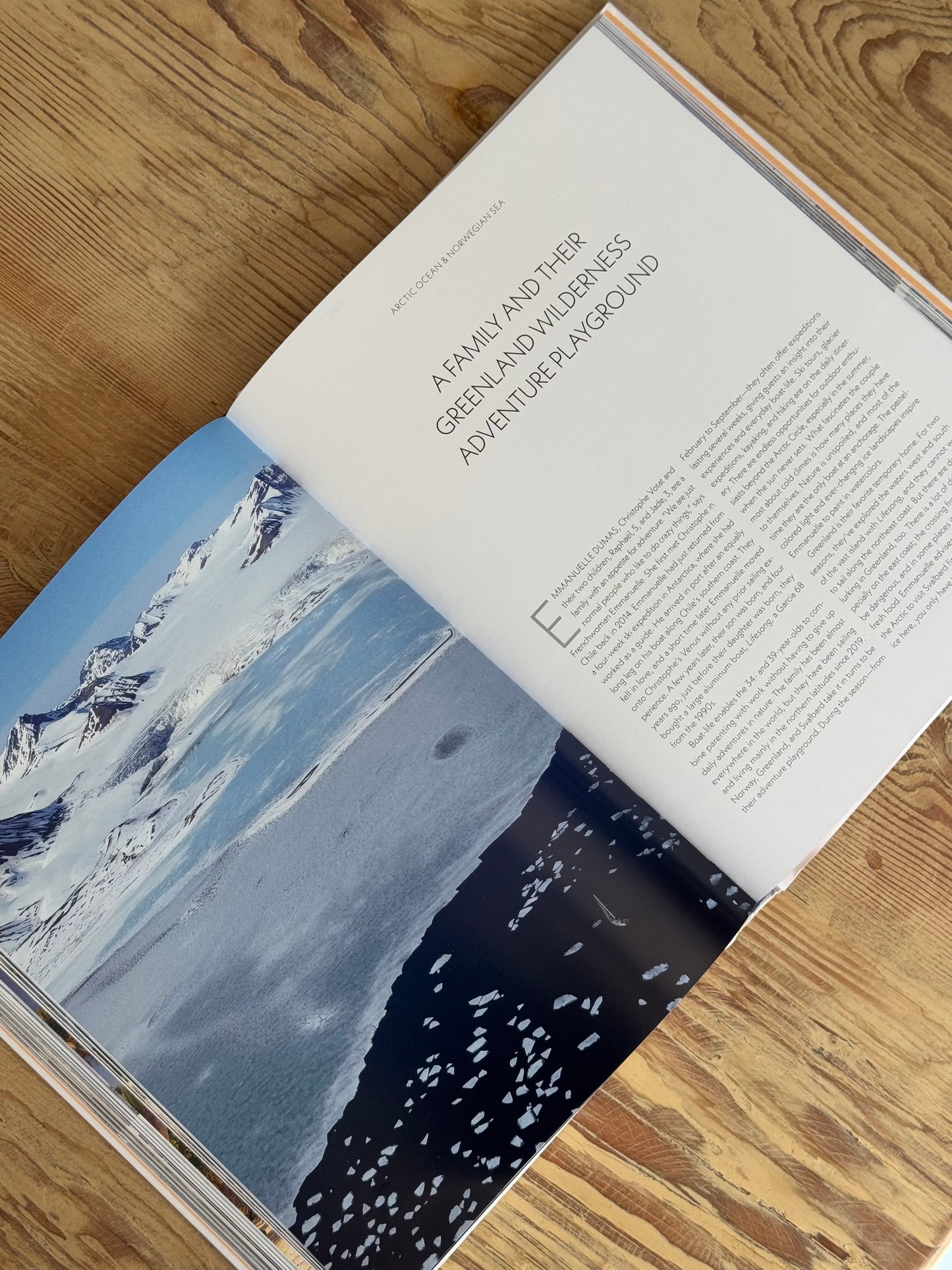 Open book with a snowy landscape and text on a wooden surface