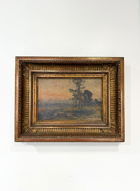 Framed painting of a landscape with trees on a white wall