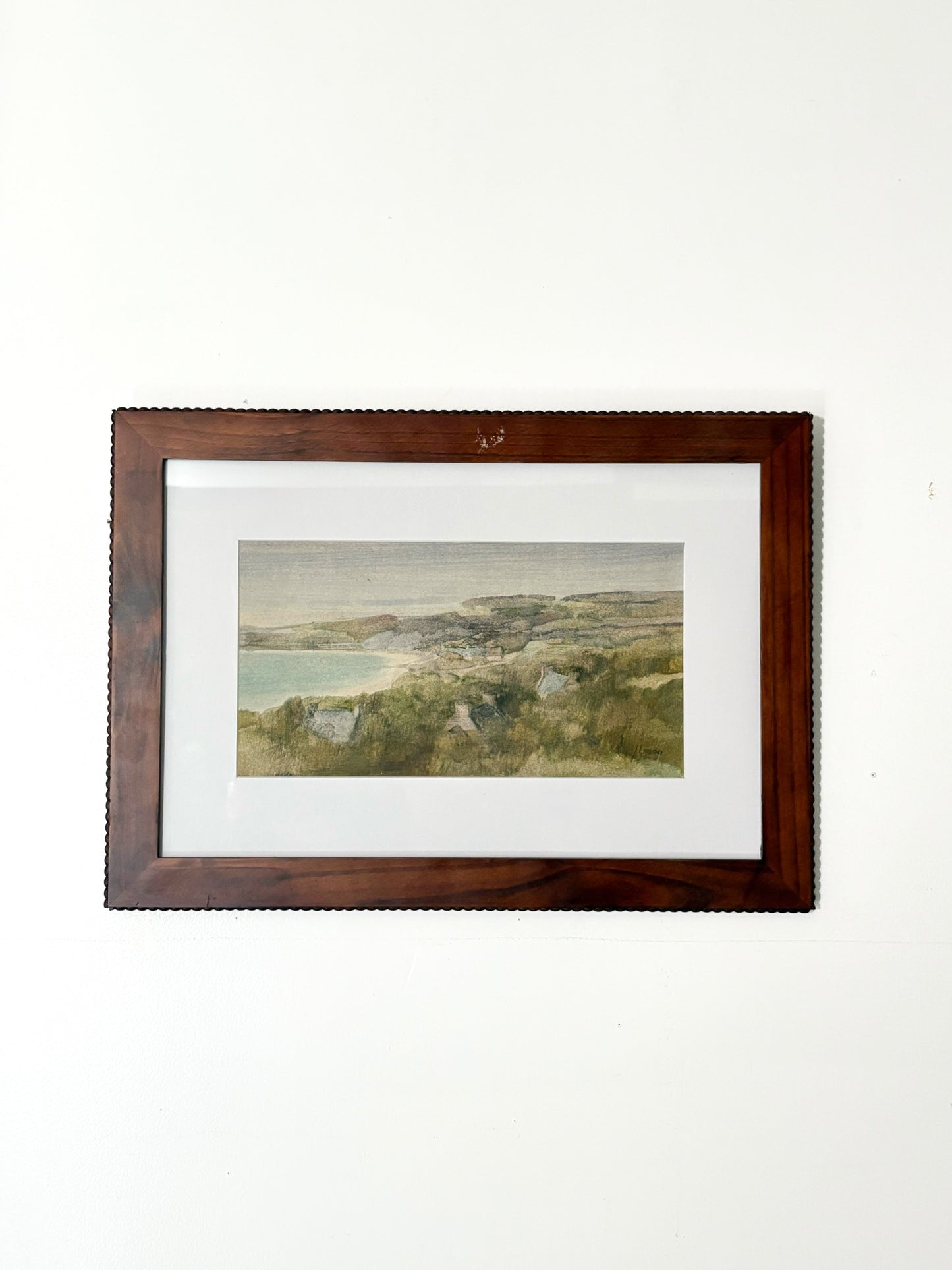 Framed landscape painting on a white wall