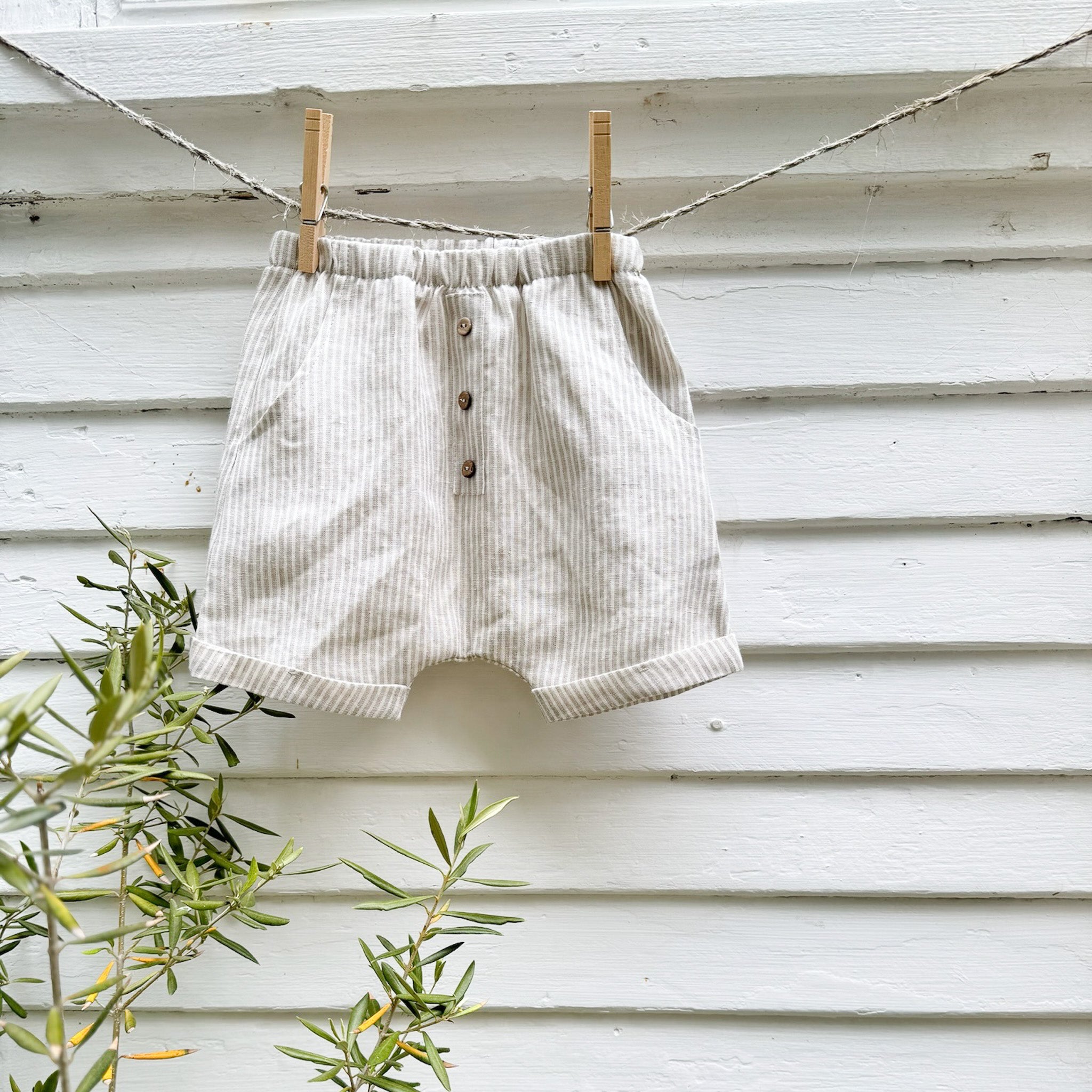 kid's linen shorts with tan and white pin stripes and three decorative  buttons in front