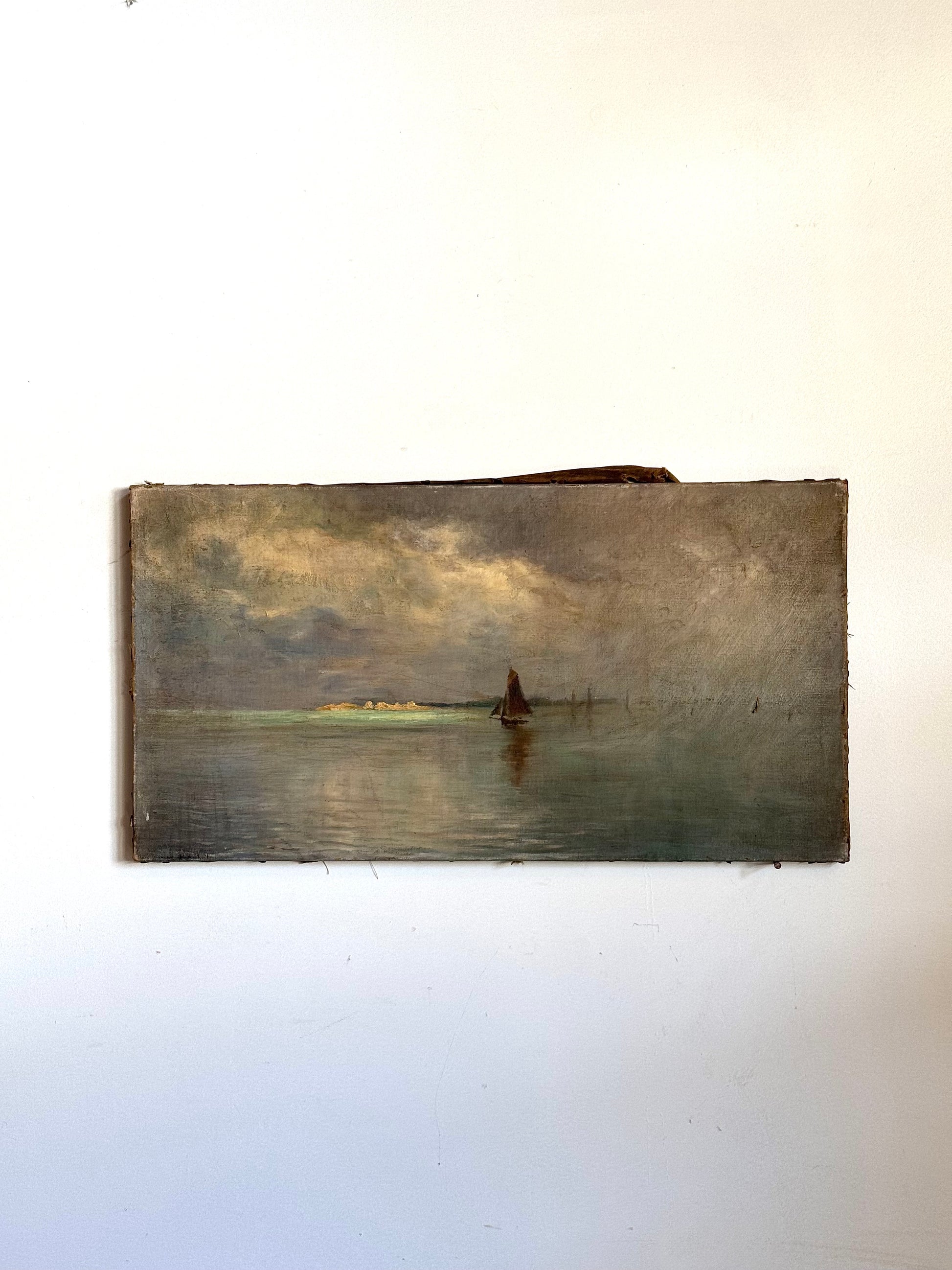 Vintage painting of a landscape with a body of water and a sailboat on a white wall.