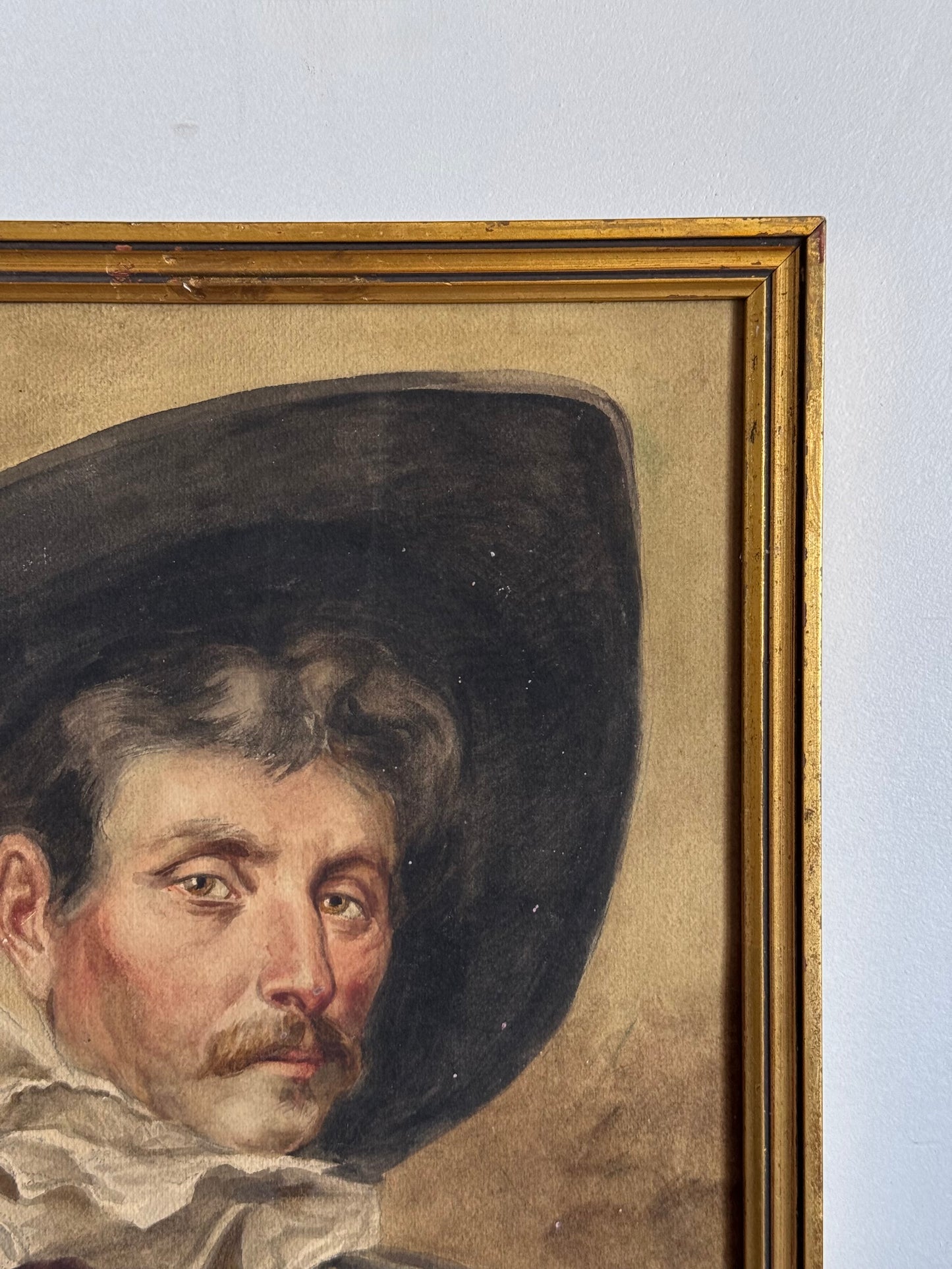 Portrait painting of a man with a dark hat and mustache, framed in gold.