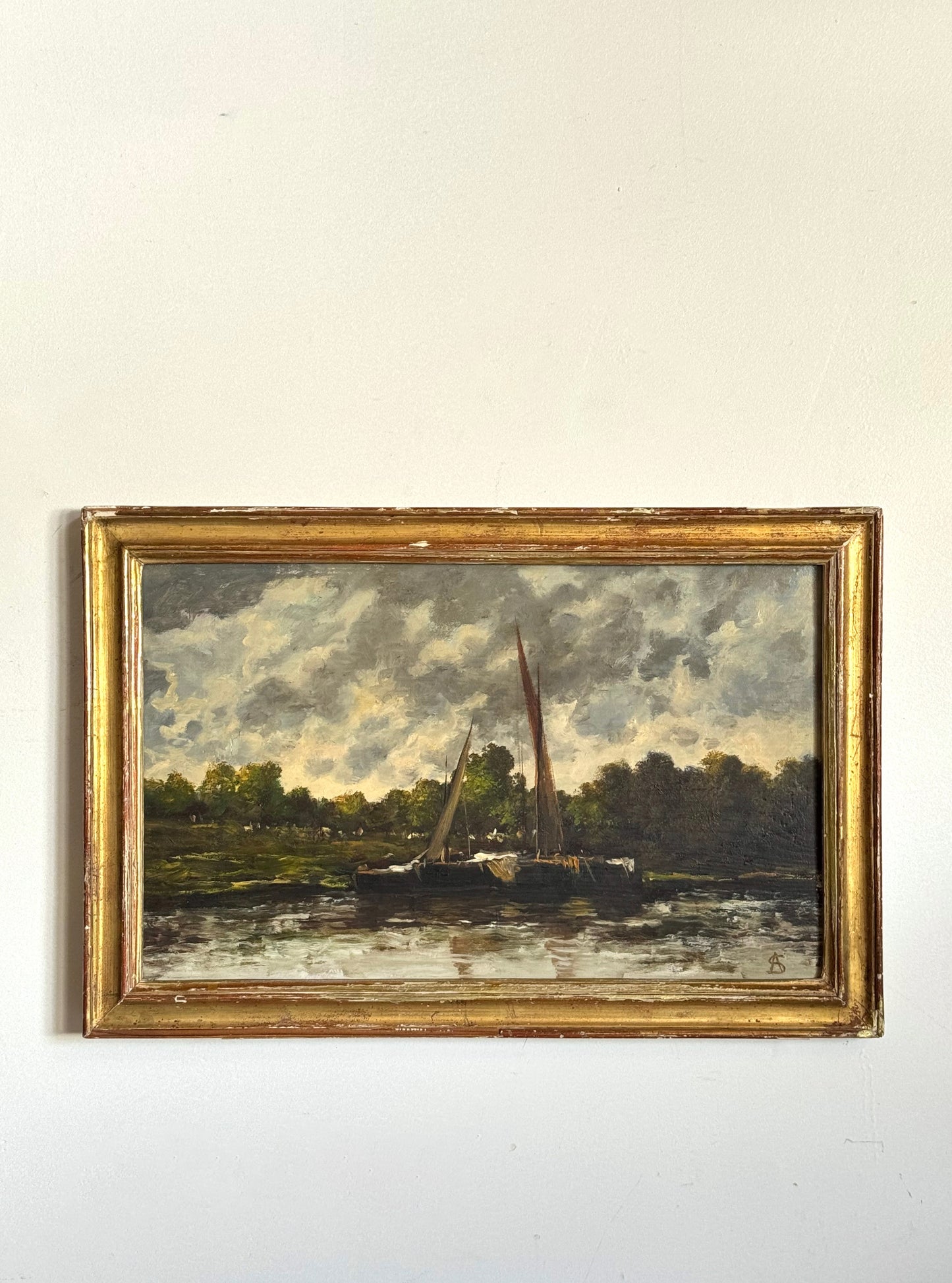 Framed painting of a landscape with boats on a river