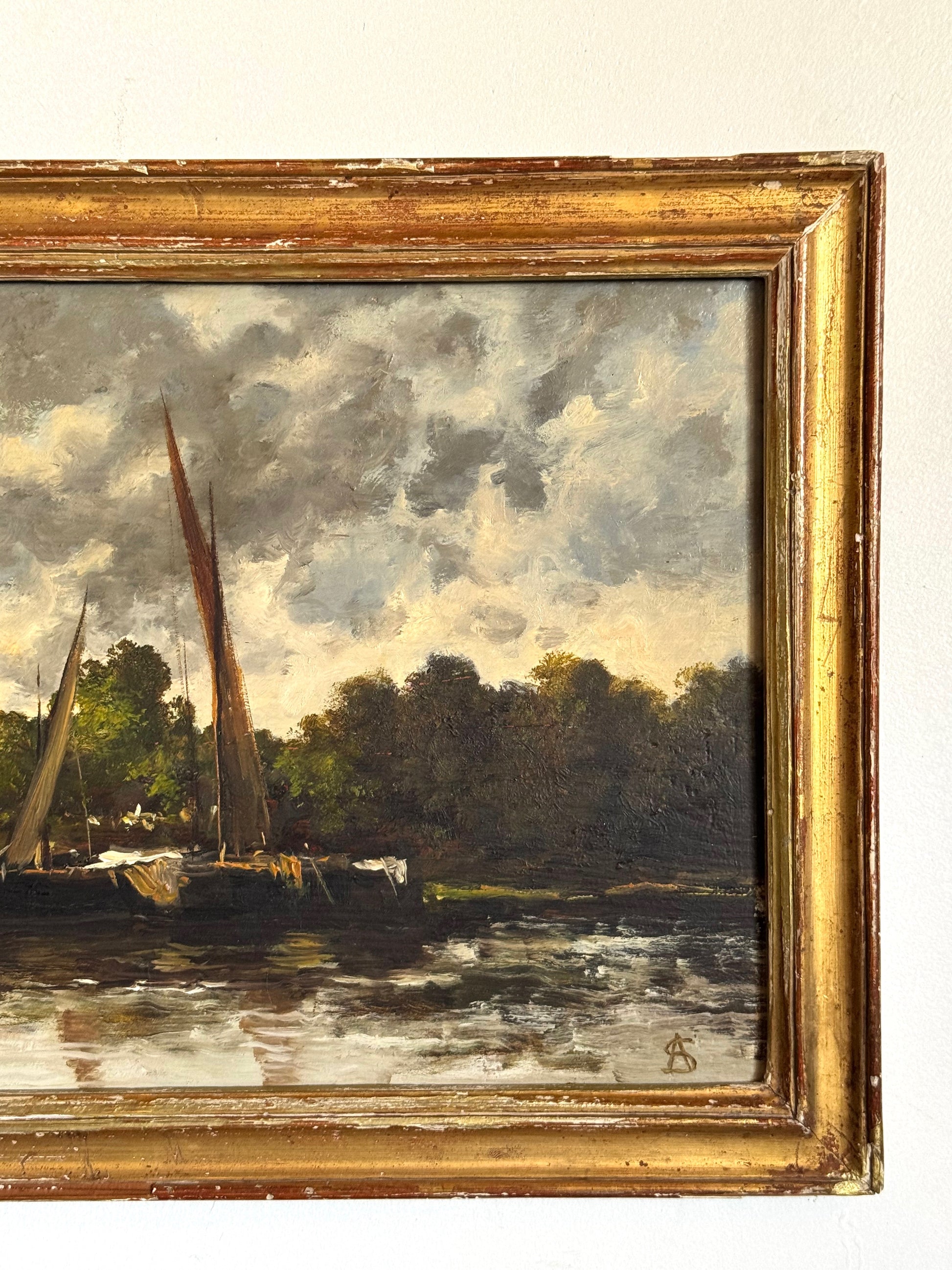 Framed painting of a landscape with boats on water and trees.