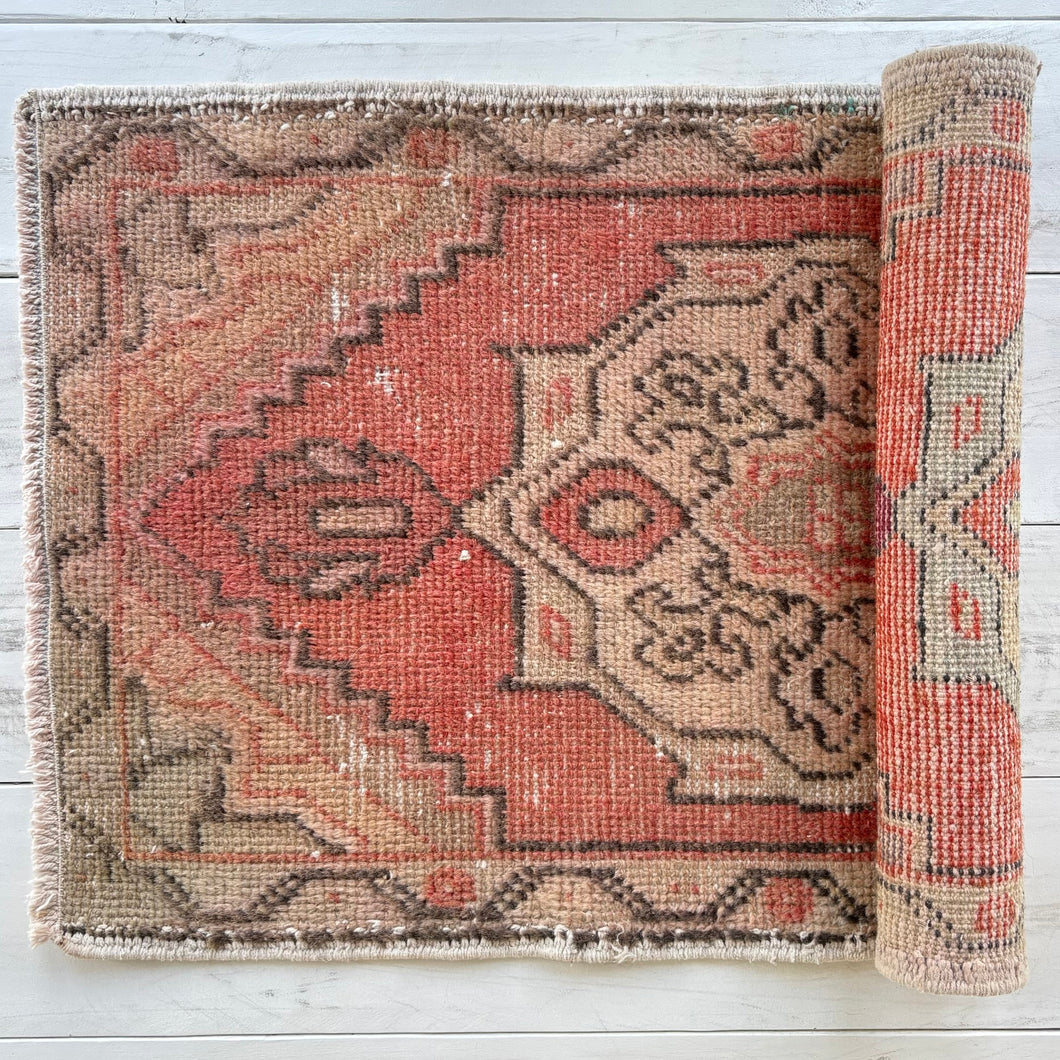 Roll of patterned rug on a wooden floor