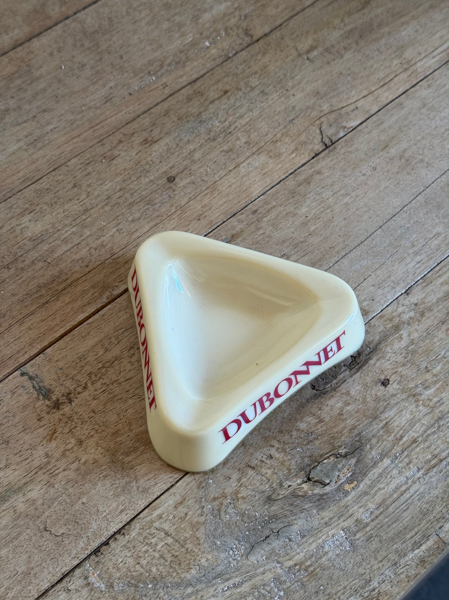 Triangular white dish with red text on a wooden surface