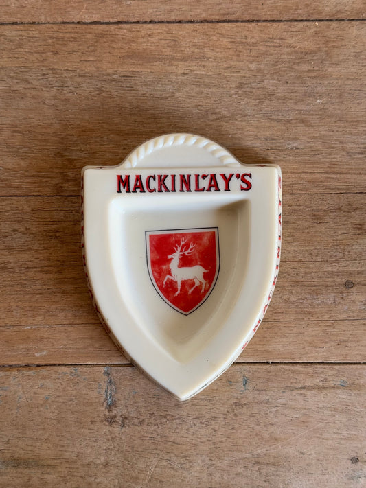 Decorative dish with 'Mackinlay's' branding on a wooden surface