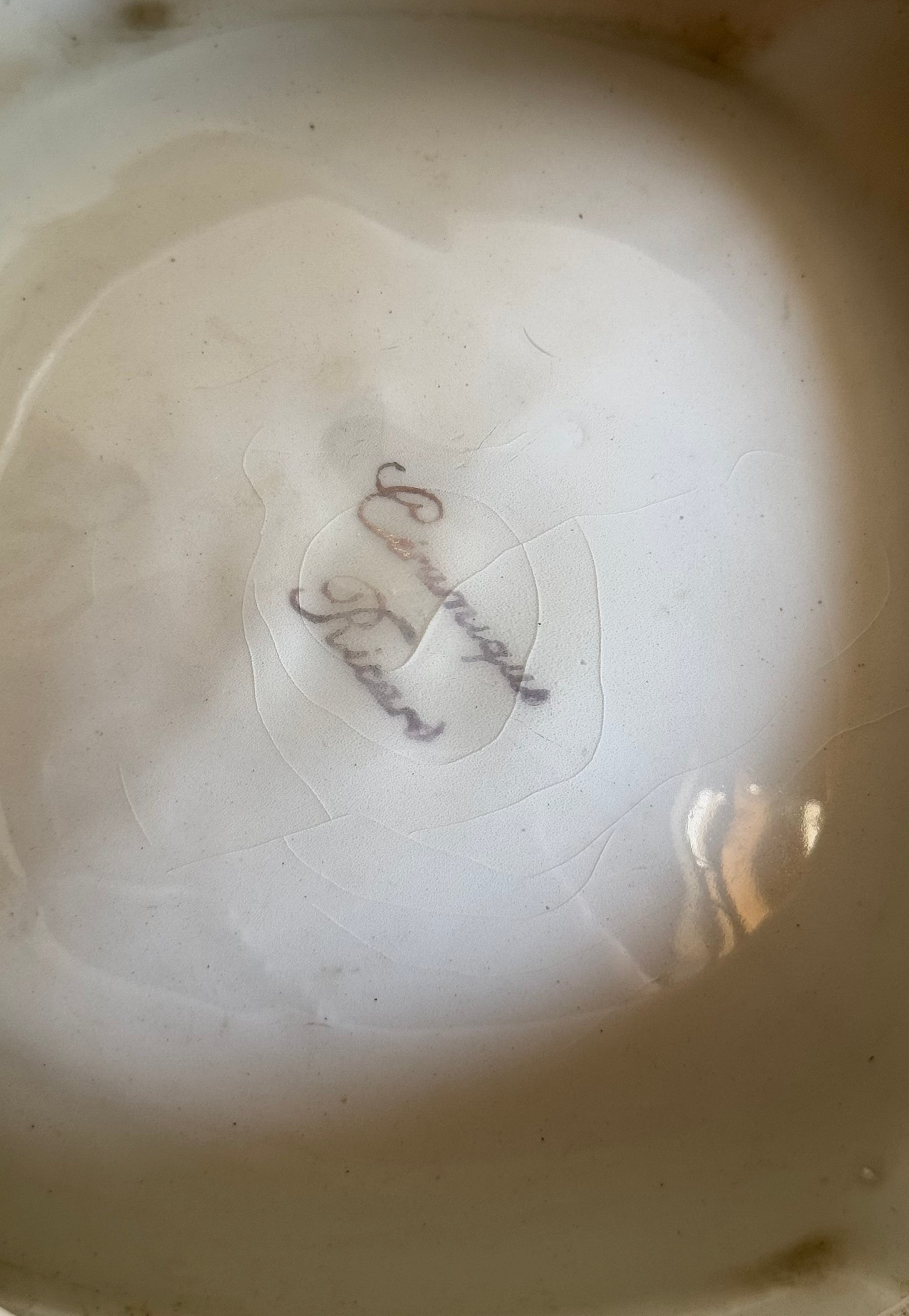 Close-up of a ceramic plate with a signature on the base