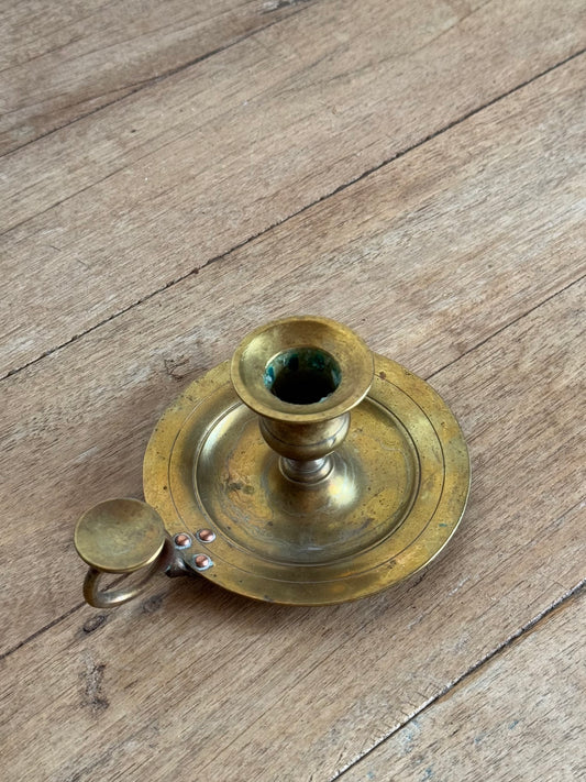 Brass candle holder on a wooden surface