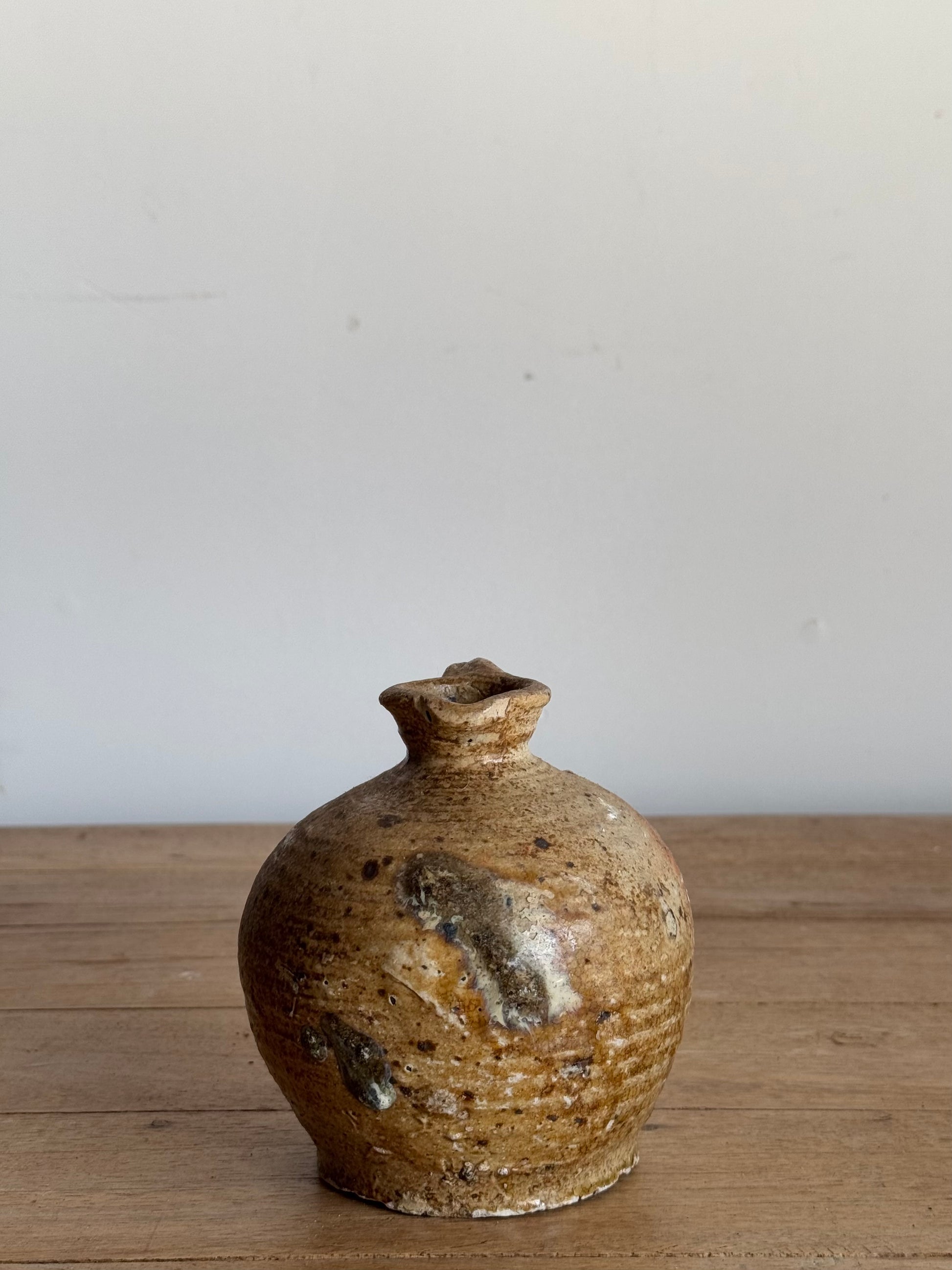 Stoneware bottle with a textured surface on a wooden table