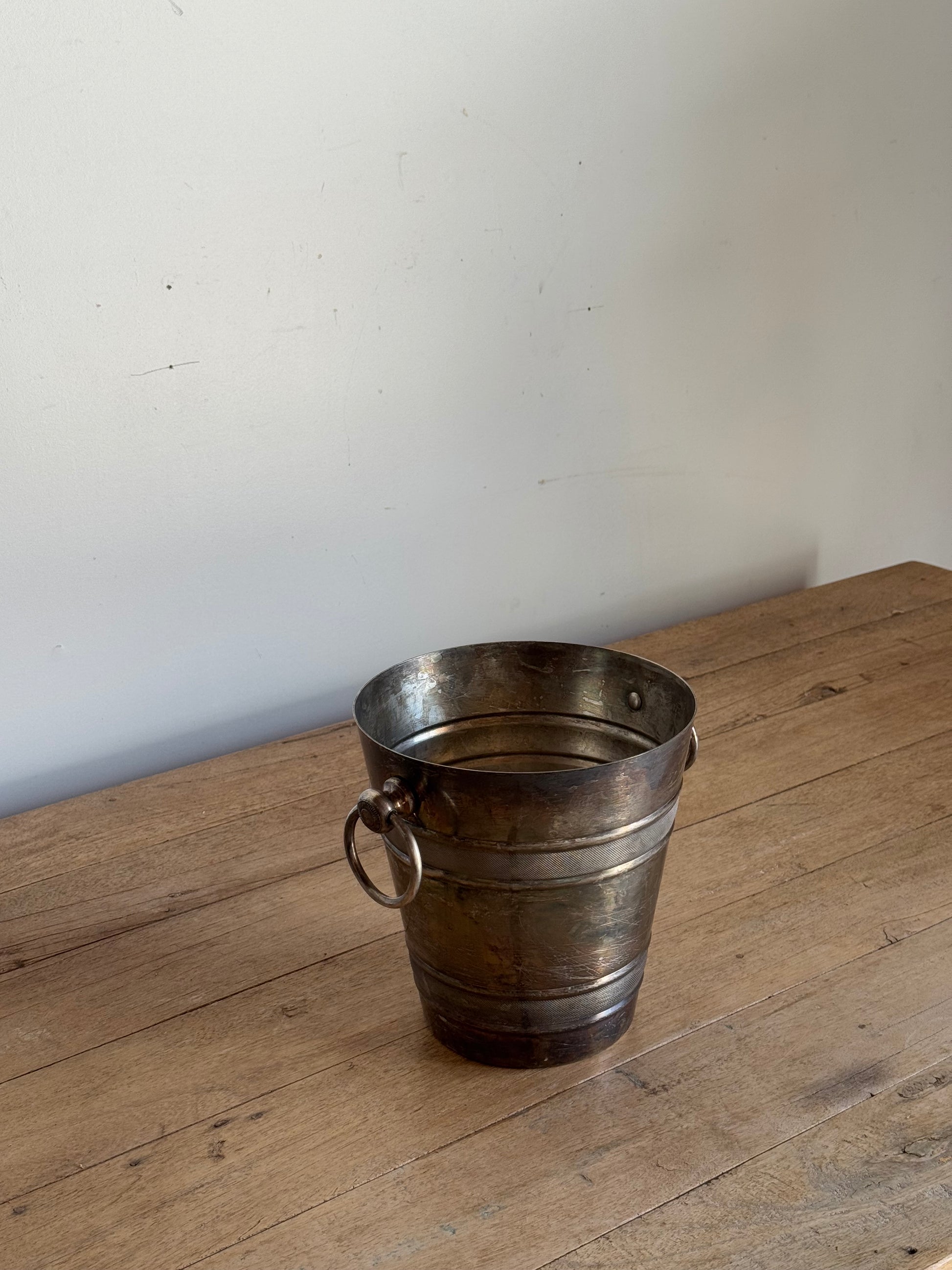Metallic bucket on a wooden surface with a white background