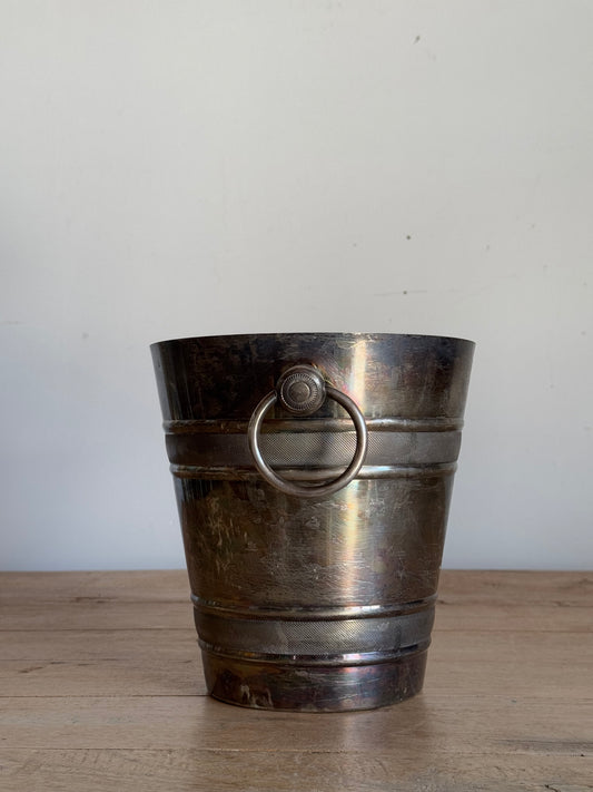 Vintage-style metal ice bucket on a white and wooden surface