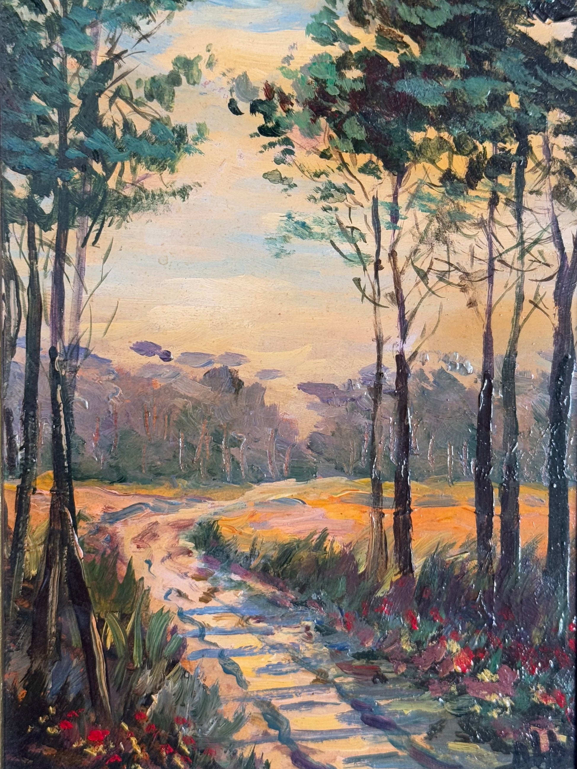 Painting of a forest path with trees and flowers at sunset.