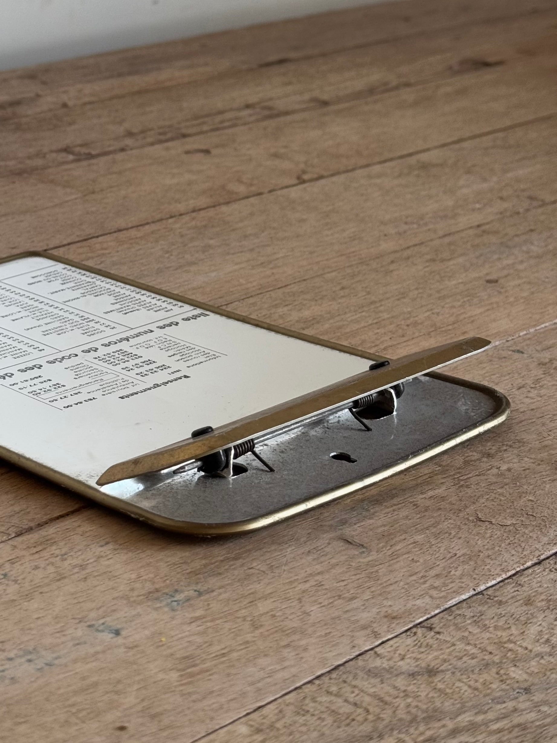 Metallic clipboard with paper on a wooden surface