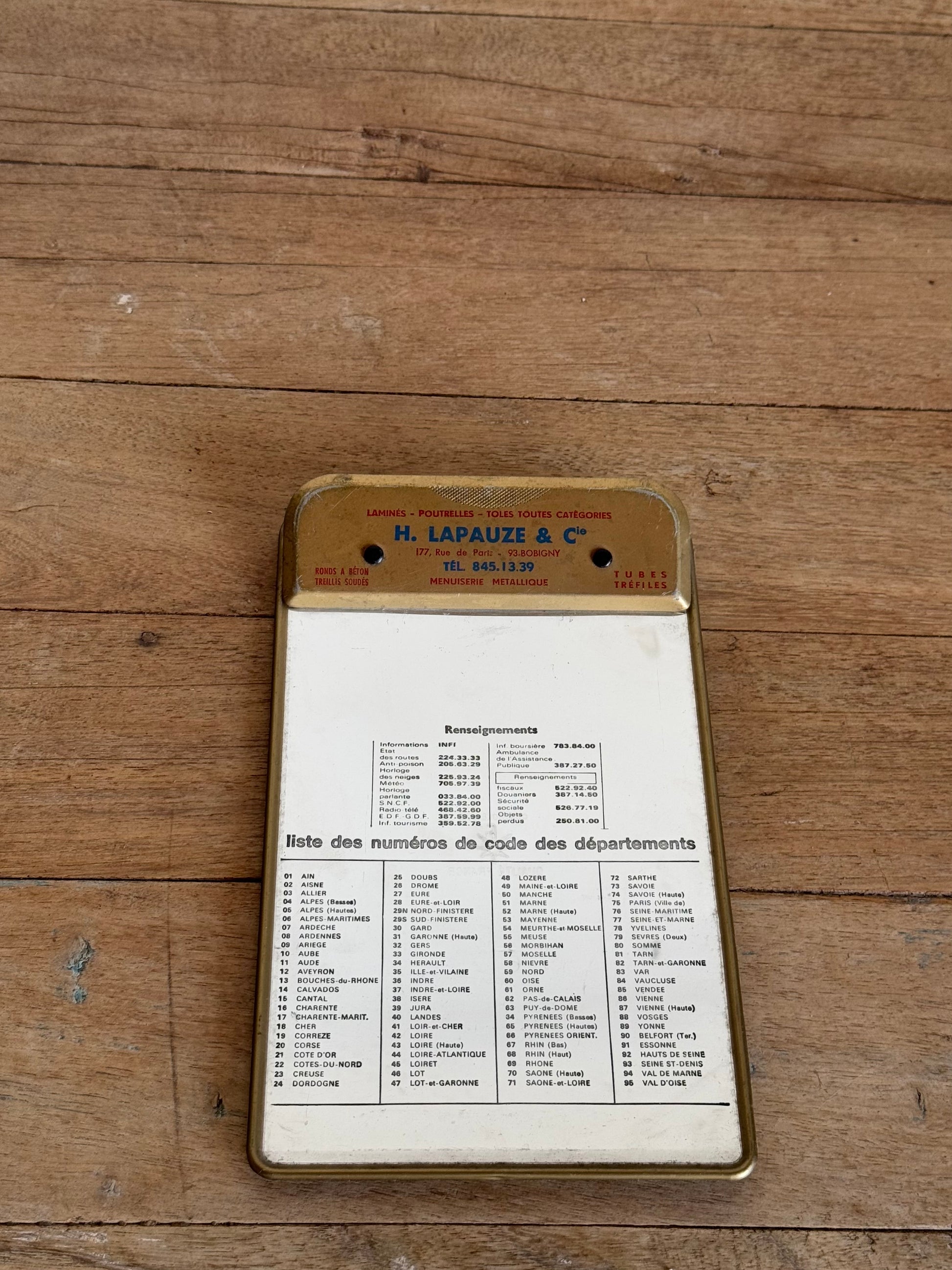 Vintage document holder with printed information on a wooden surface