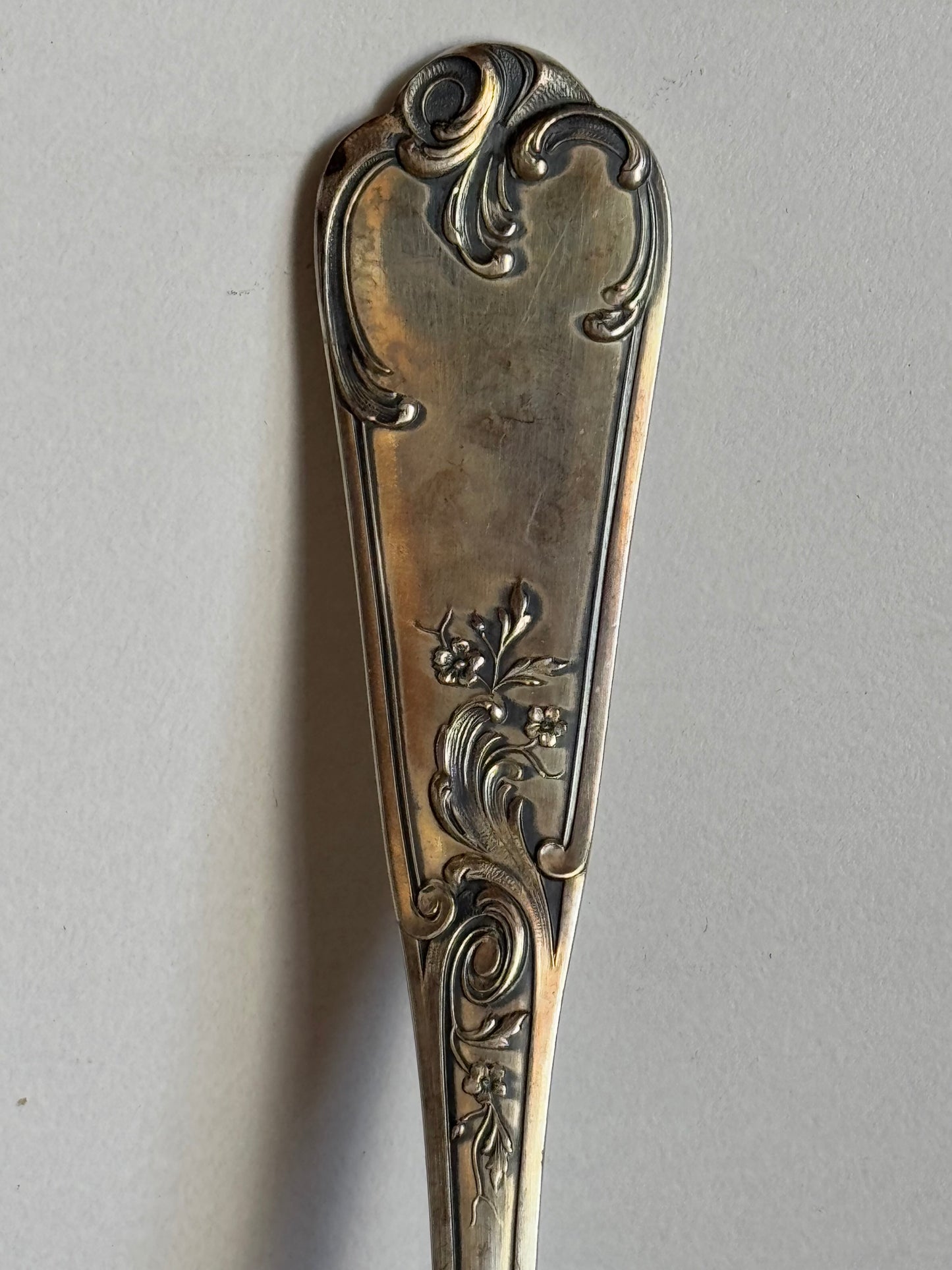 Decorative silver spoon on a light gray background