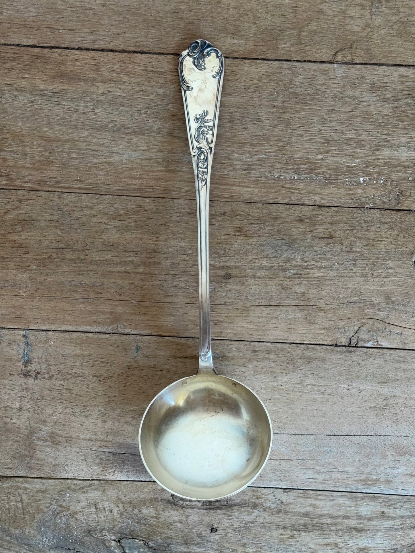 Silver ladle on a wooden surface