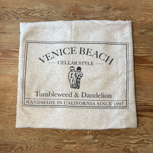 Beach blanket with 'Venice Beach' branding on a wooden surface