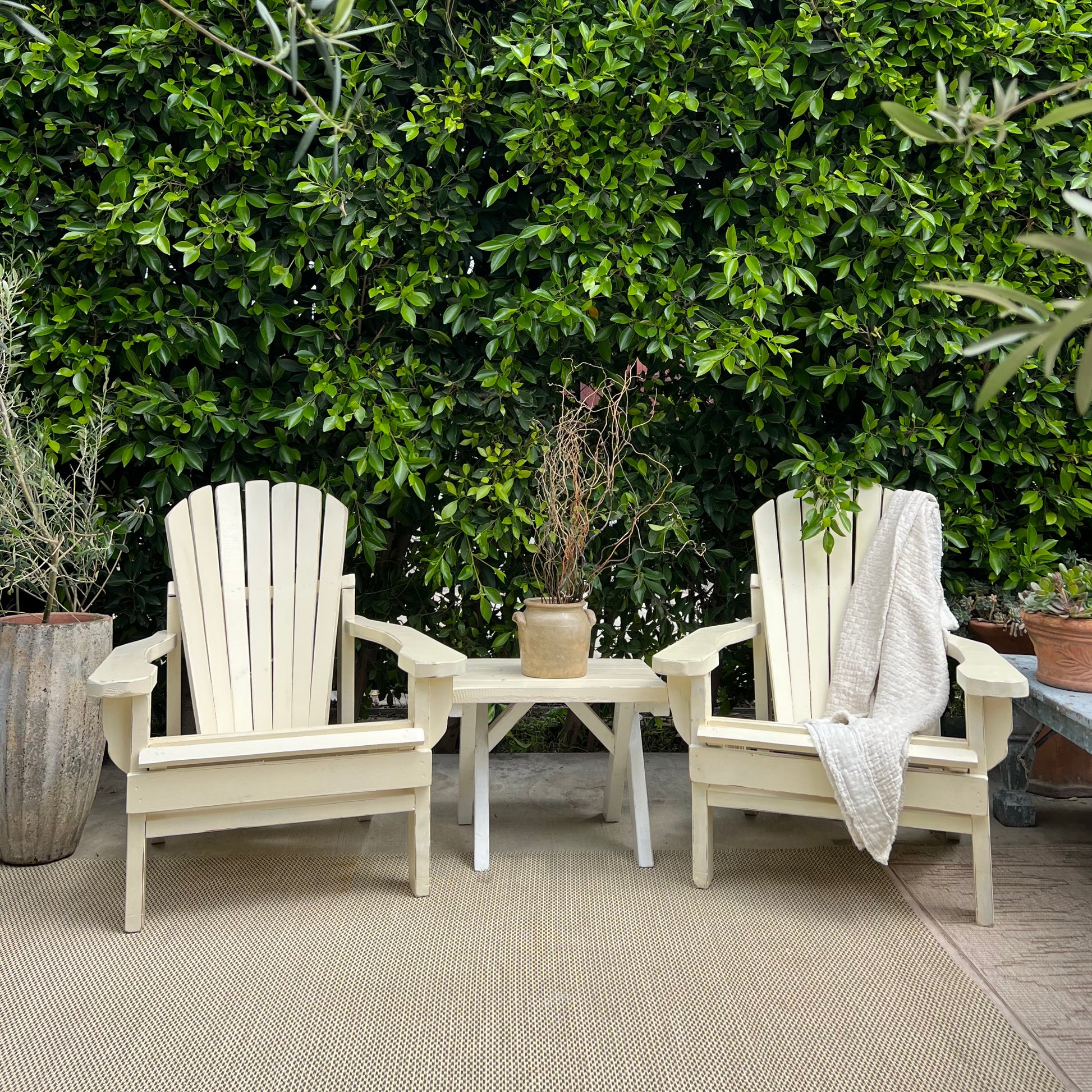 cream colored painted Adirondack chairs and side table