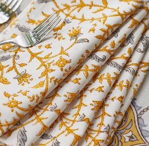 white cloth napkin with yellow and gray vine patterns
