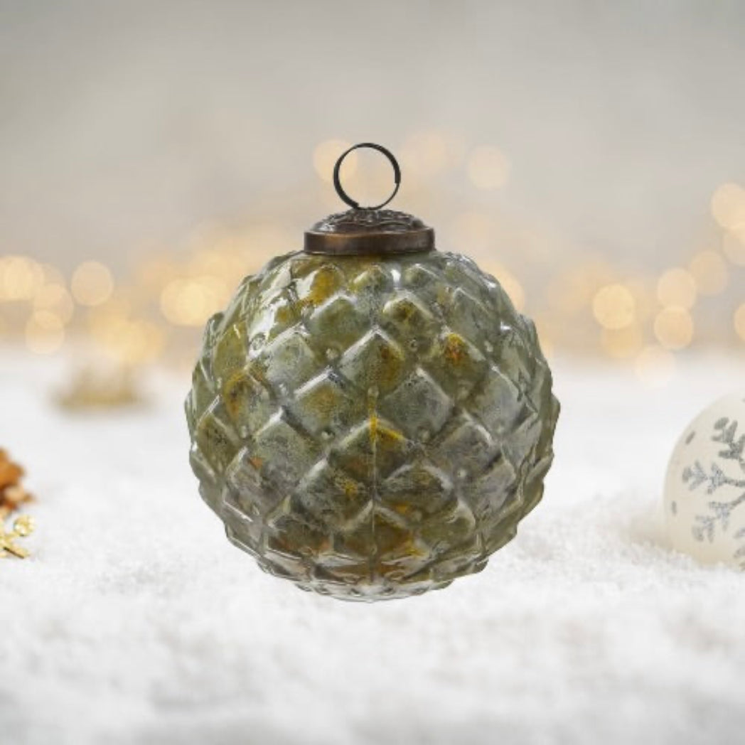 Decorative glass ball ornament with textured surface on a blurred background