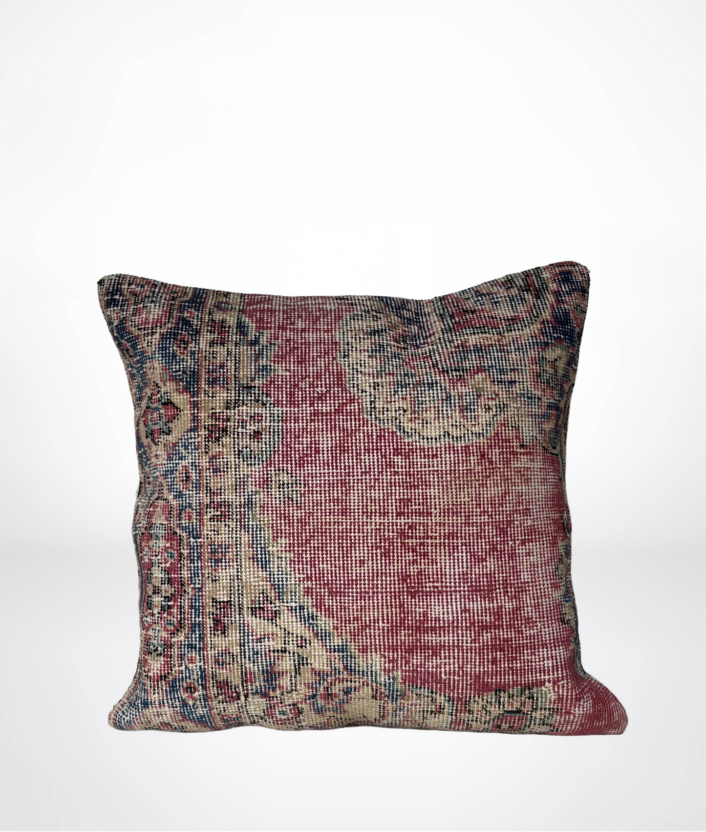 A square throw pillow featuring a distressed, vintage-style Persian or oriental rug pattern in muted red, beige, and blue tones, set against a plain white background.