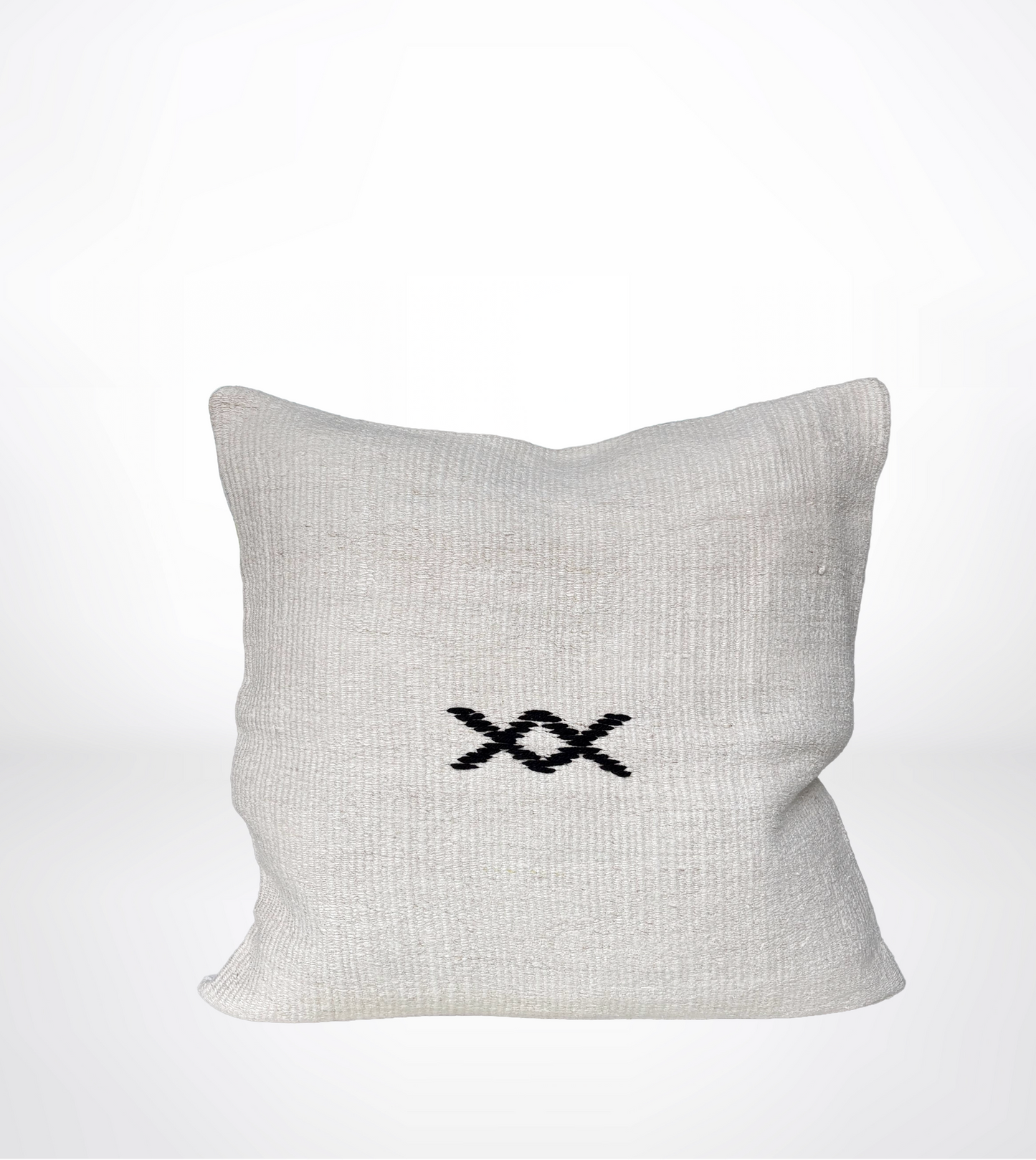 A square off-white linen throw pillow with a black embroidered double-X symbol in the center, set against a clean white background.