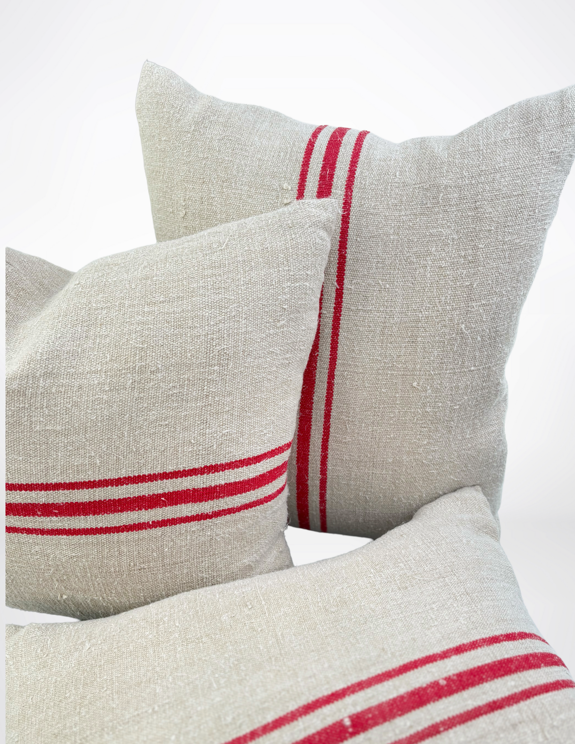 Three pillows with red stripes on a white background