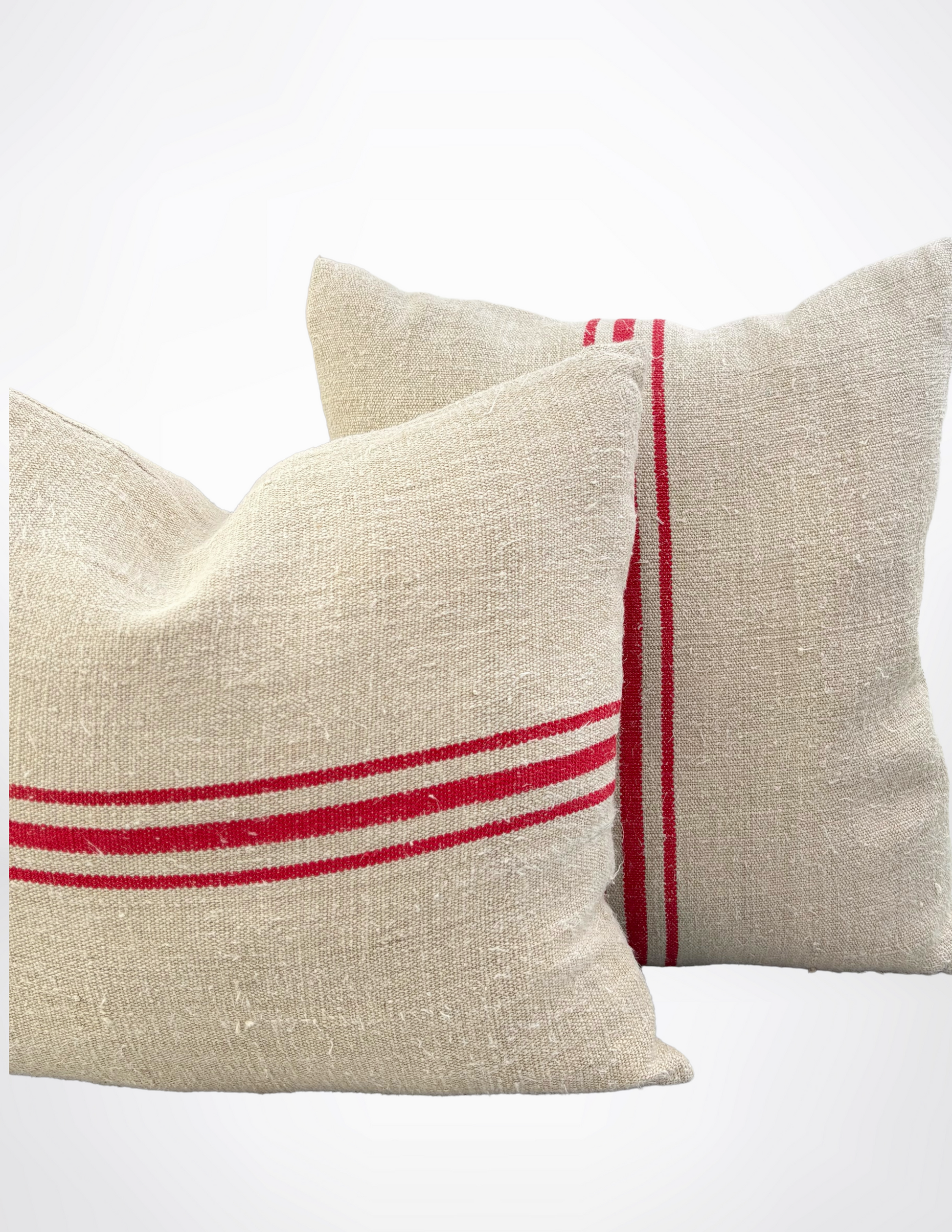 Two beige pillows with red stripes on a white background
