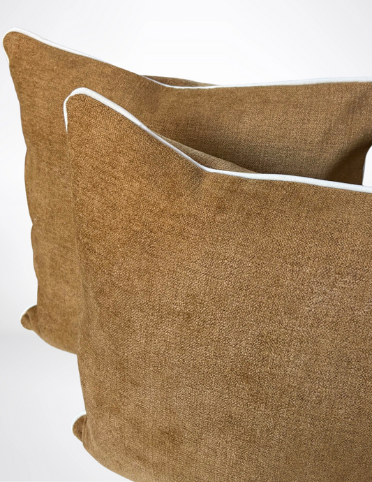 brown pillows with white piping