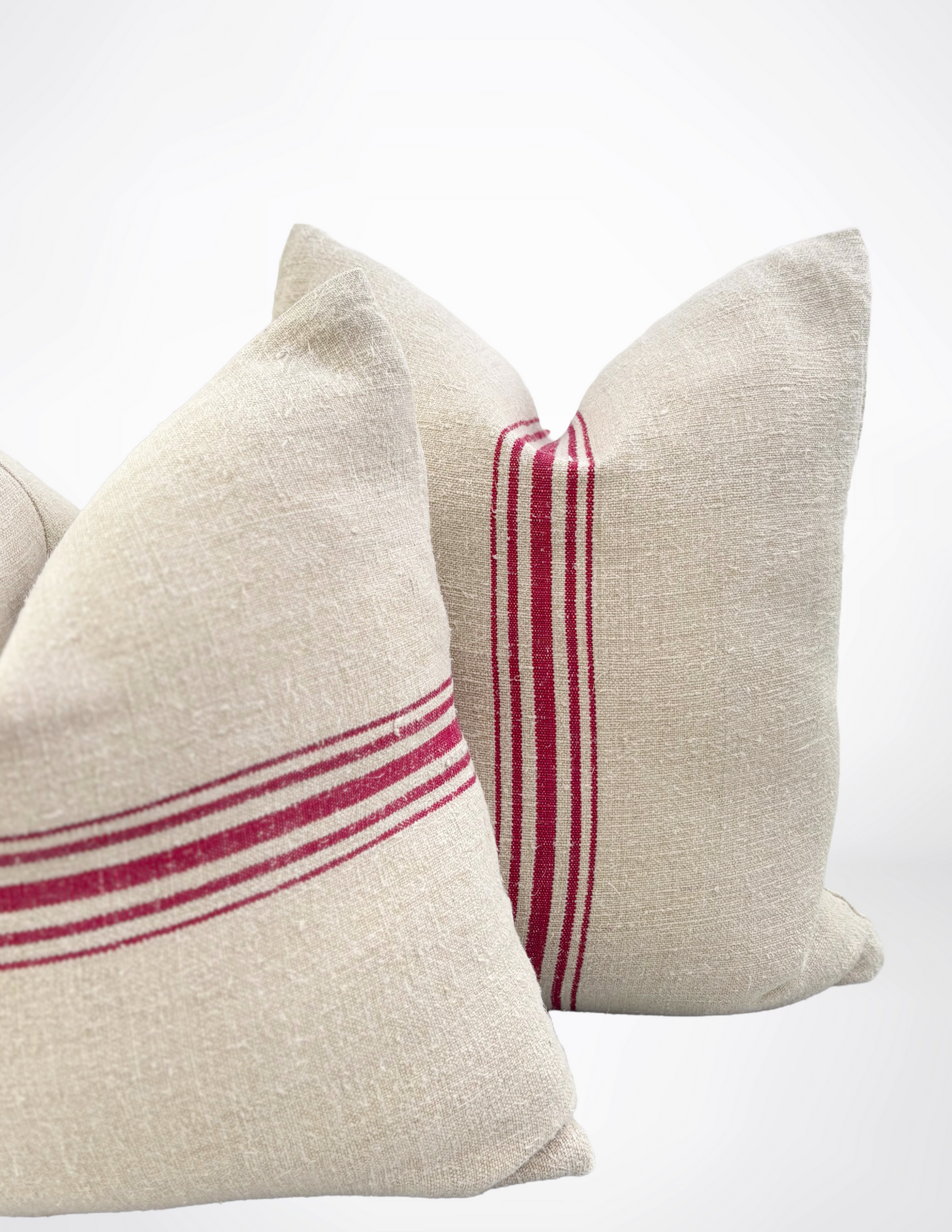 Two beige pillows with red stripes on a white background