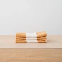 Load image into Gallery viewer, Stack of folded towels with orange and white stripes on a beige surface.