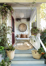 Load image into Gallery viewer, photo of a front porch of a cottage house, with wicker loveseat, rattan rug, red screen door, porch floor is painted a sage green and lots of plants