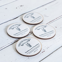 Load image into Gallery viewer, white round wood drink coaster with black Tumbleweed and Dandelion logo