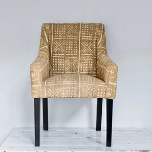 tan and white patterned mud cloth upholstered chair with black wood legs