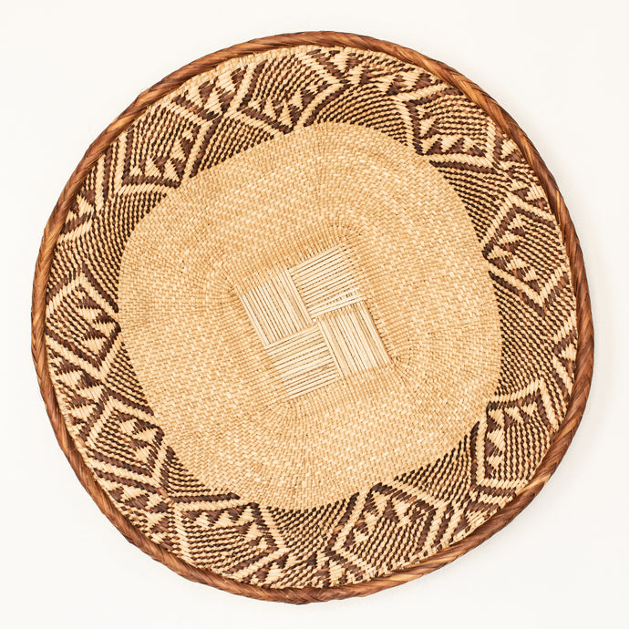Round woven wicker tray with tan and brown pattern