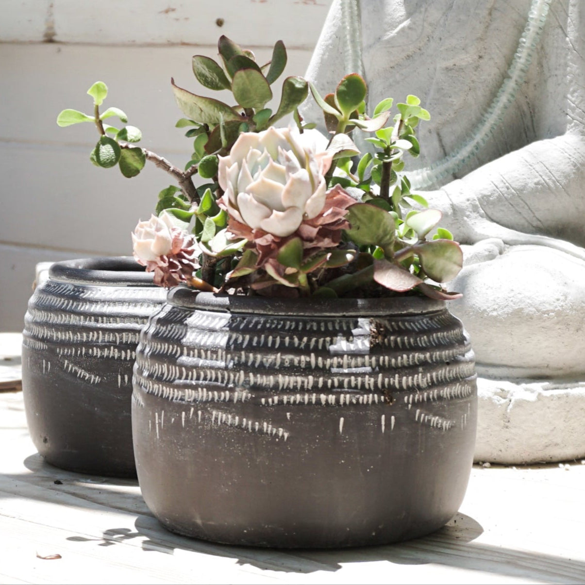 Black ceramic pot with white markings around top