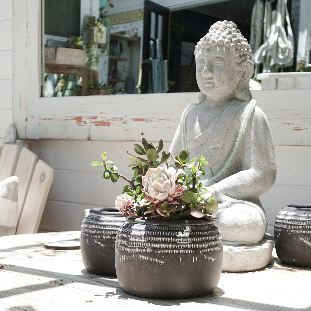 Black ceramic pot with white markings around top