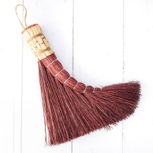 small hand held rust colored broom