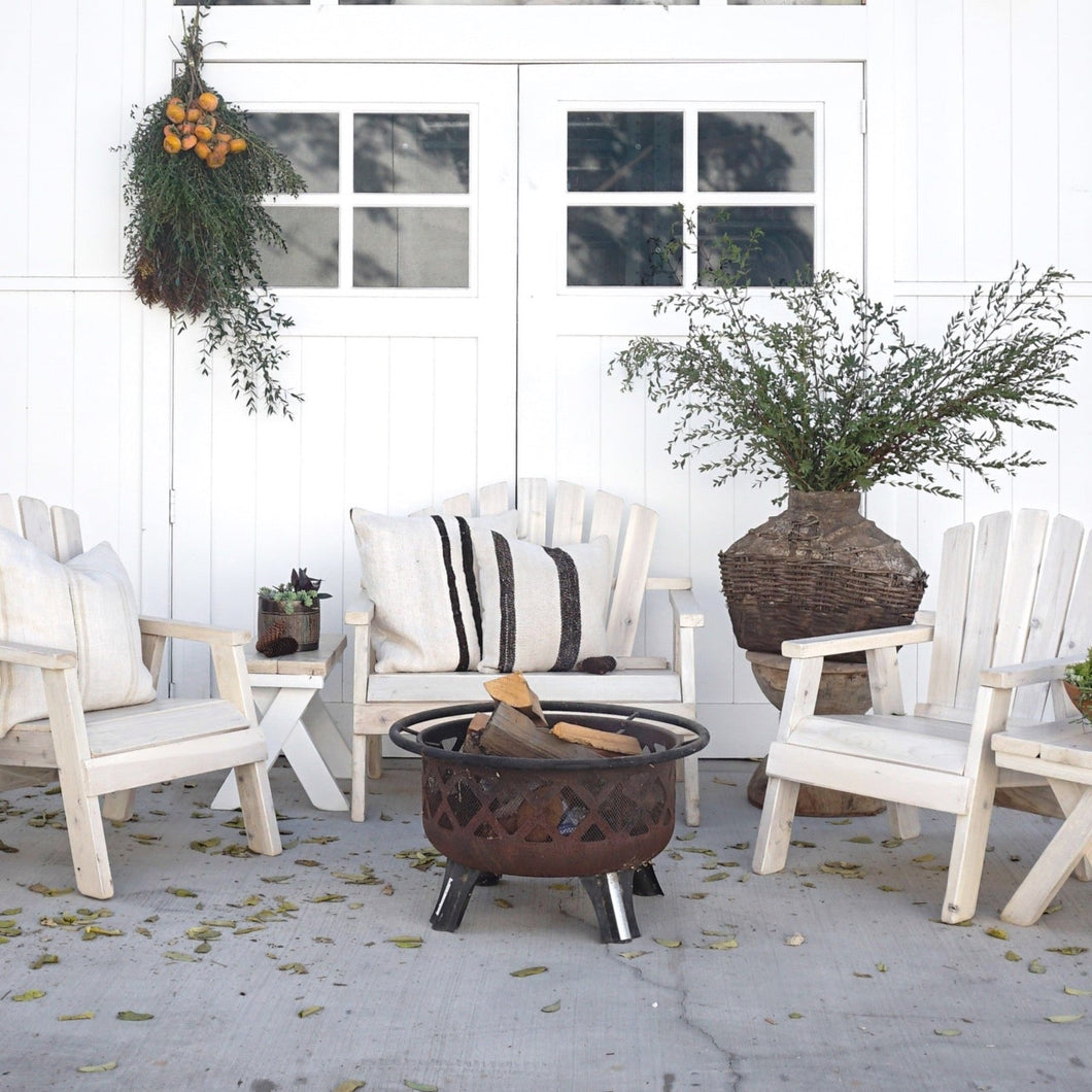 white washed wood patio set with one bench, two chairs and side table