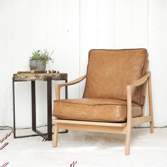 wood chair with brown leather cushions and a wood and iron side table