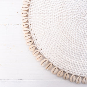 round white rattan placemat with off white shells on edge