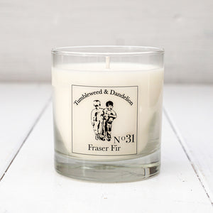 Fraser fir scented clear glass candle with Tumbleweed and Dandelion logo