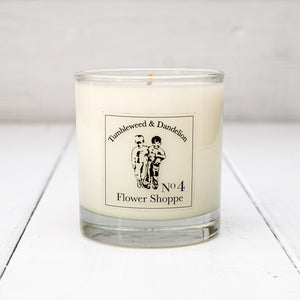Clear glass candle with Tumbleweed and Dandelion logo, flowery scent