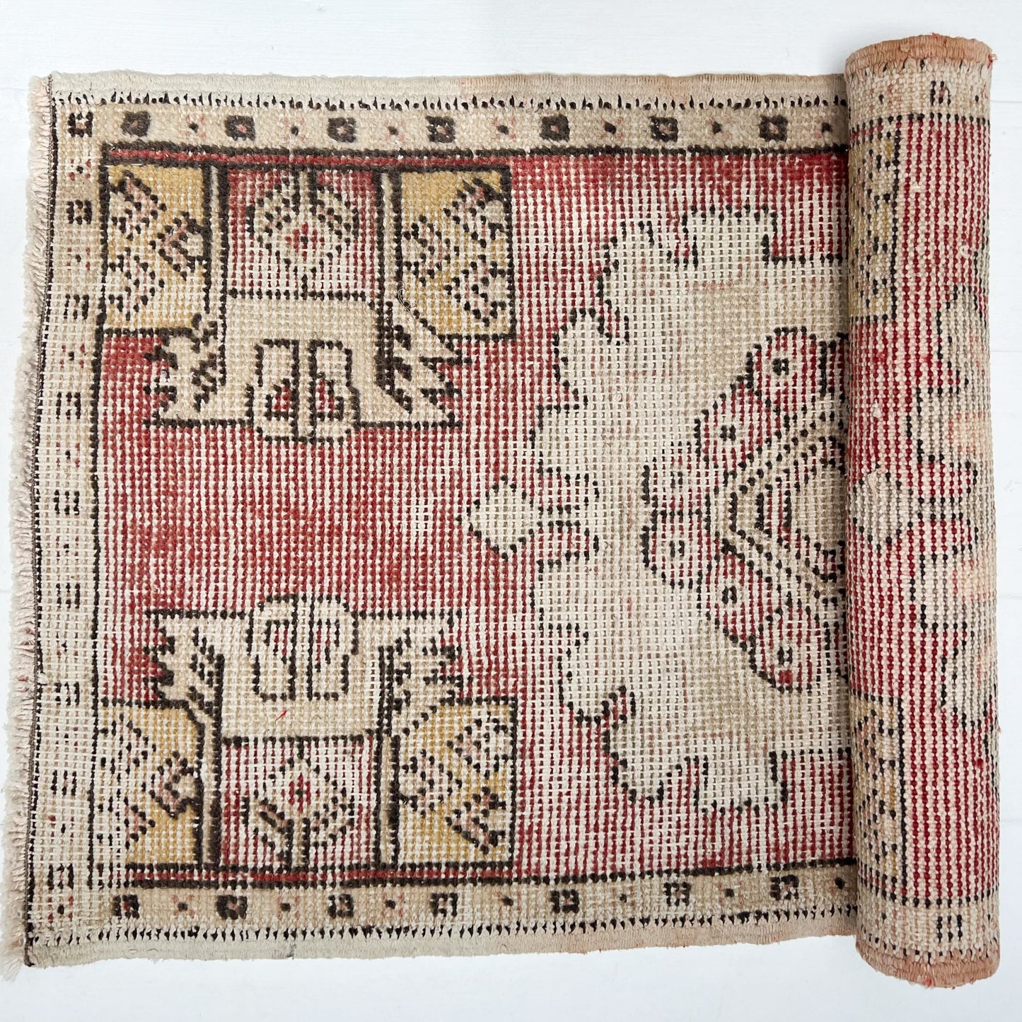 red and cream colored small Turkish rug