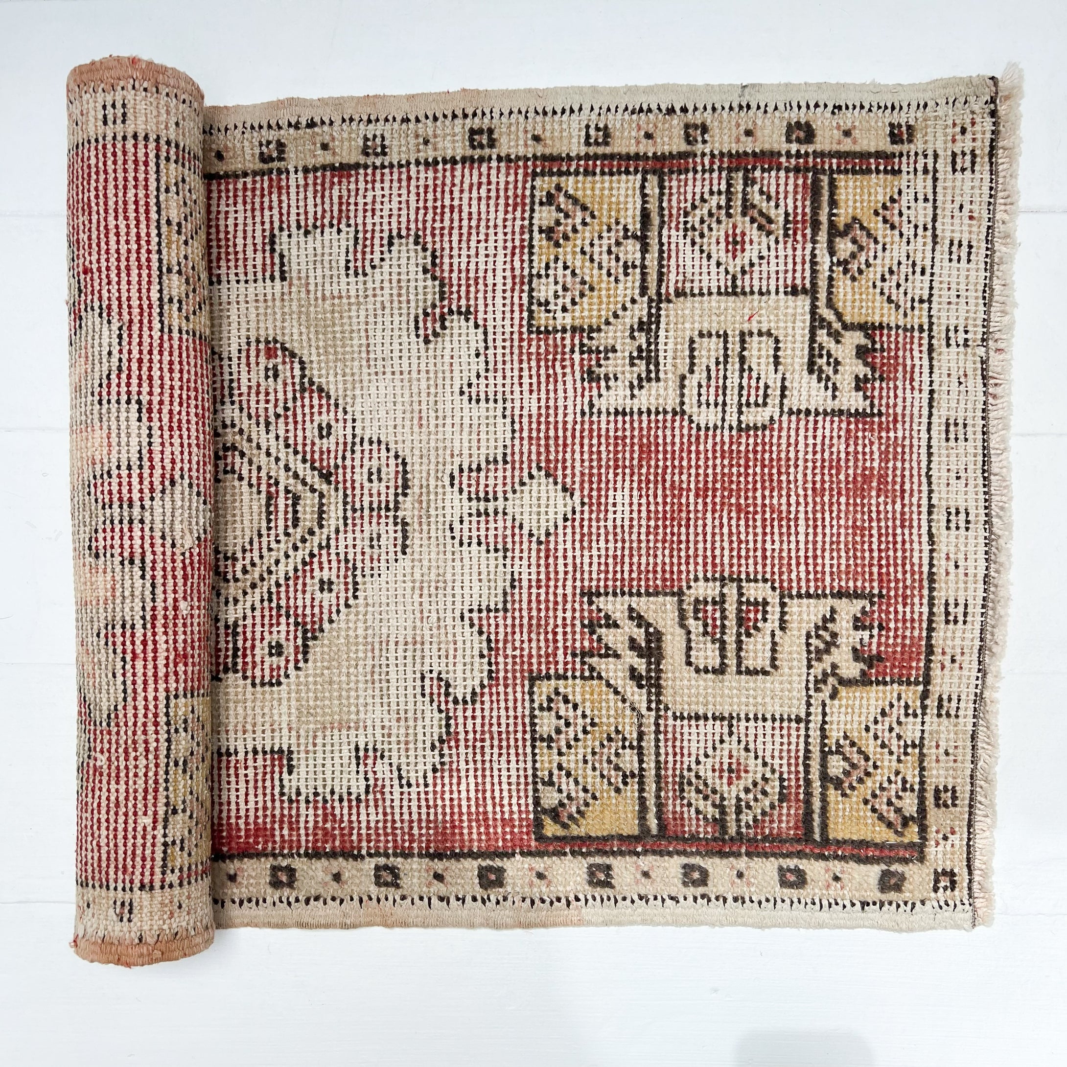 red and cream colored small Turkish rug