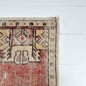 red and cream colored small Turkish rug