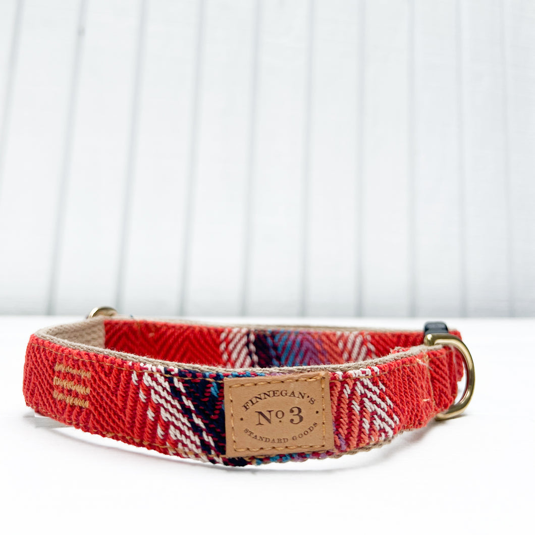 red cotton dog collar with white, black and blue detail with black plastic  clip and brass rings