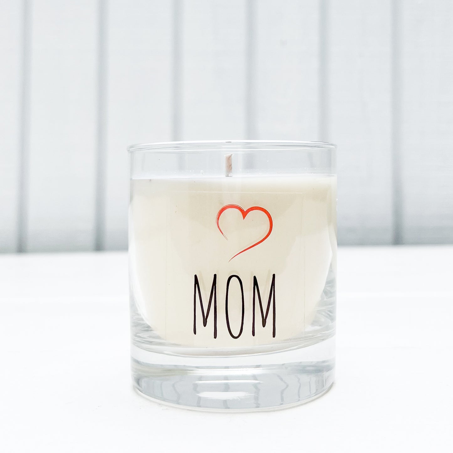 clear glass candle with MOM in black and a red heart