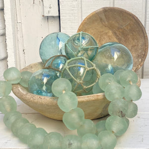 round green/blue glass balls, some with rope around them